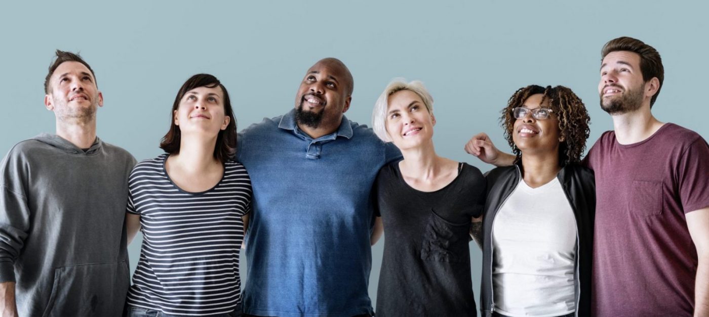 Seis personas en grupo sonriendo y mirando hacia arriba, formación para el empleo