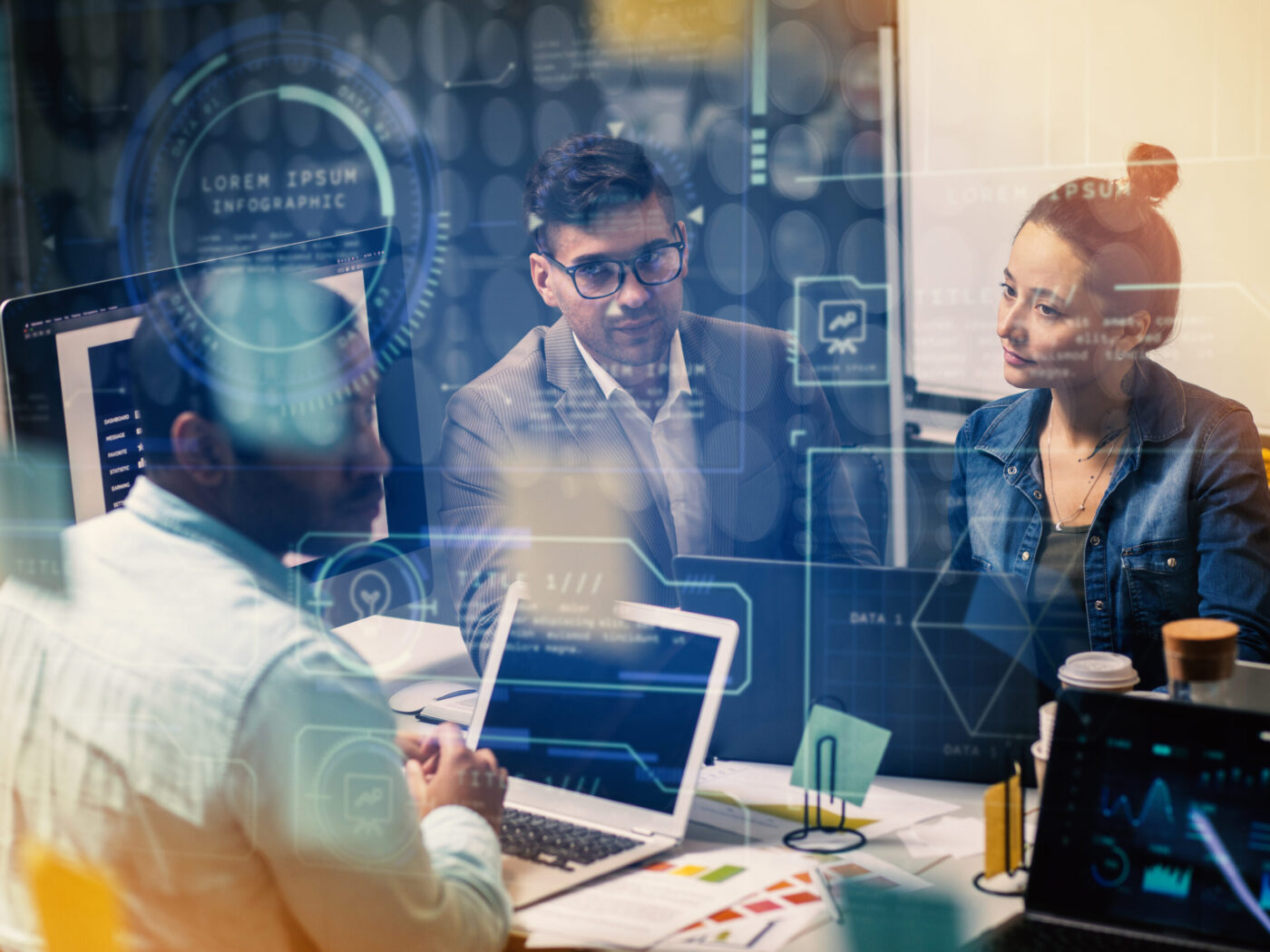 Tres profesionales reunidos con portátiles en una oficina, cursos online