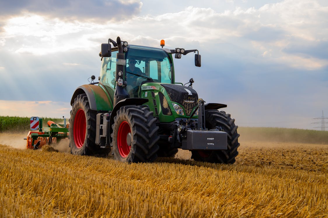 Tractor verde Fendt tirando un apero agrícola en un campo de cereal