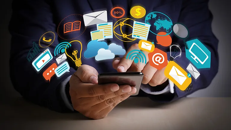 Manos sosteniendo un teléfono móvil con iconos digitales flotantes, cursos online