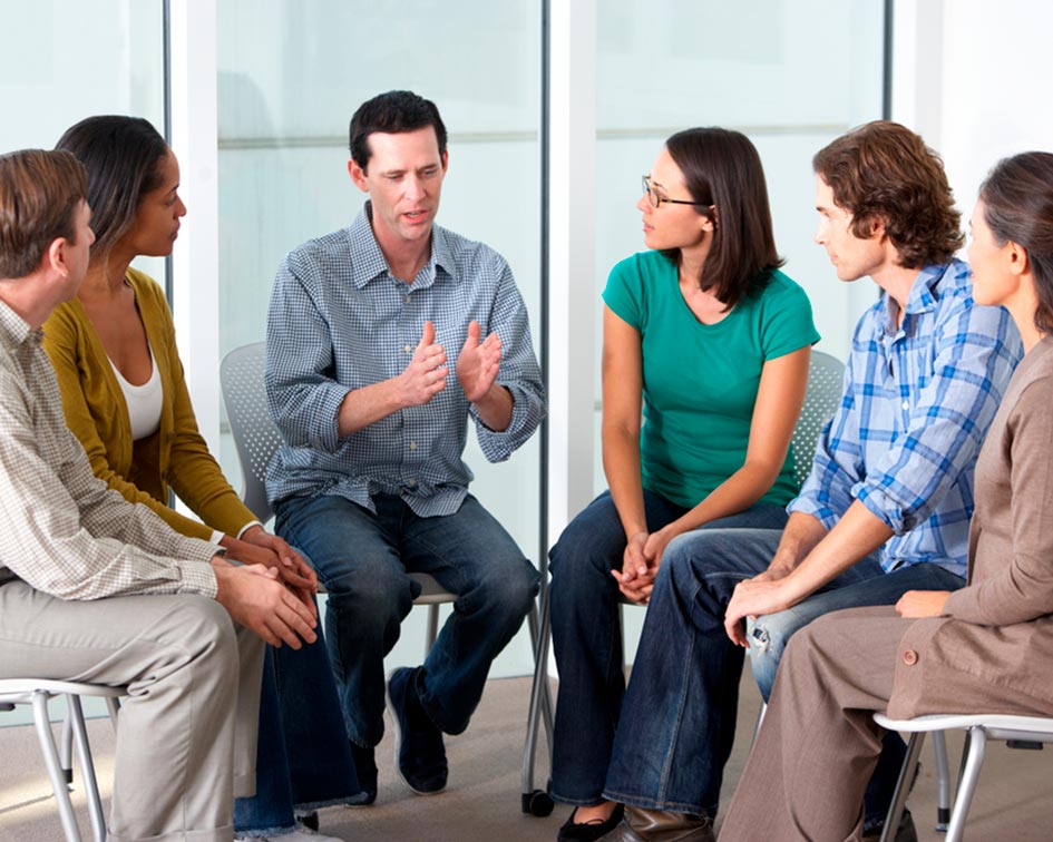 Hombre hablando en círculo en una sesión grupal de formación para el empleo