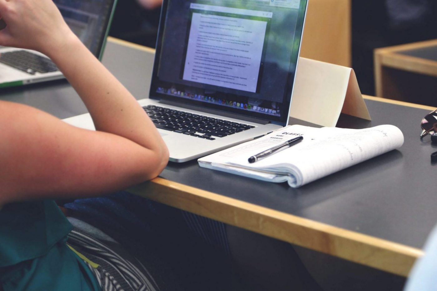 Estudiante con portátil y cuaderno, cursos online
