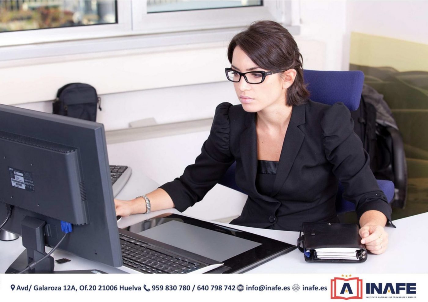 Mujer con gafas trabajando frente a un ordenador en oficina, formación profesional Huelva