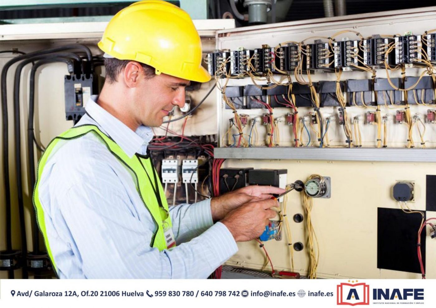 Técnico con casco amarillo realizando mantenimiento industrial en un cuadro eléctrico