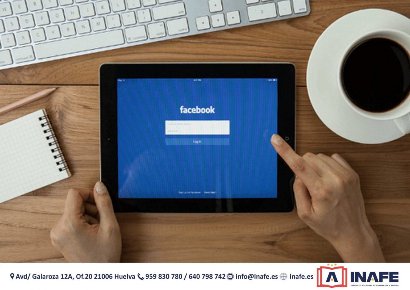 Tablet con la pantalla de inicio de Facebook, manos tocando la pantalla y taza de café — cursos en Huelva