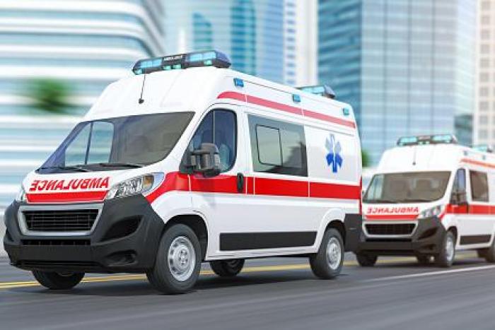 Ambulancia blanca con franja roja y luces azules en circulación — formación para administraciones públicas