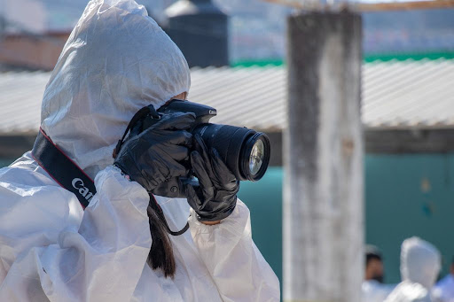 Persona con mono protector y guantes fotografiando con cámara réflex Canon — cursos sector industrial