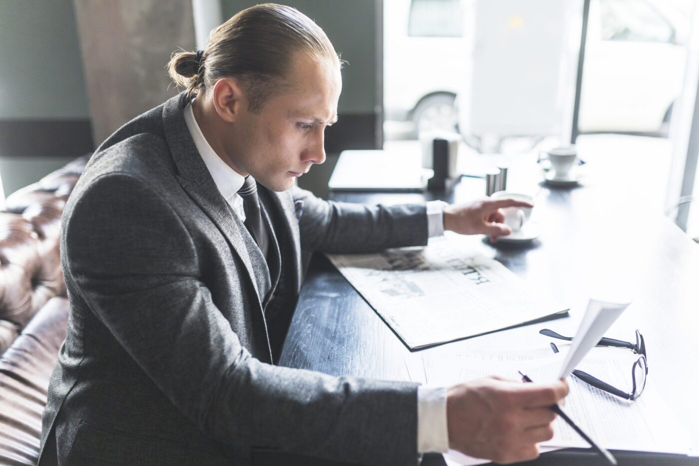 Hombre con traje revisando documentos sobre la mesa, formación para el empleo