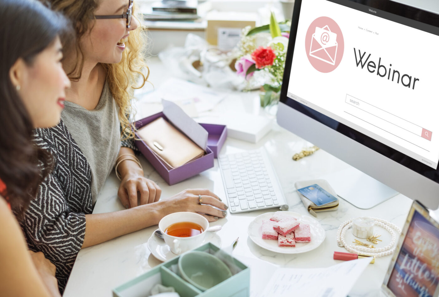 Dos mujeres mirando un ordenador con la palabra 'Webinar' en pantalla — cursos online