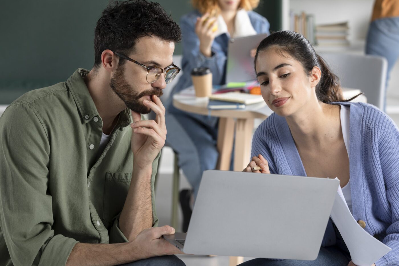 Dos personas colaborando delante de un portátil, cursos online